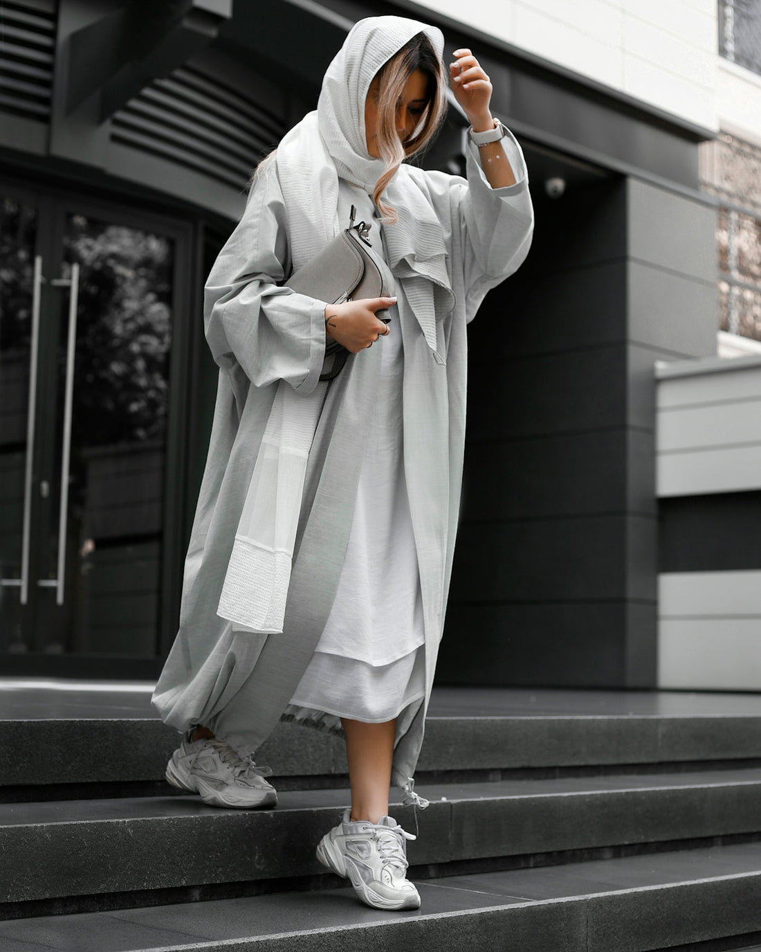 a woman in a white robe is standing on some steps