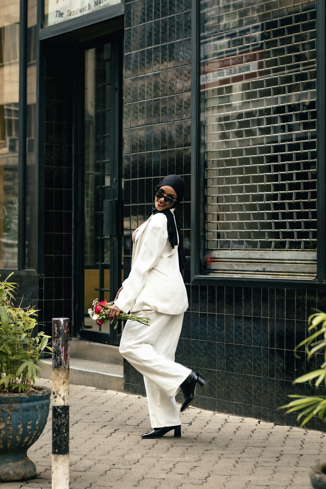 A woman in a white outfit walking down a street