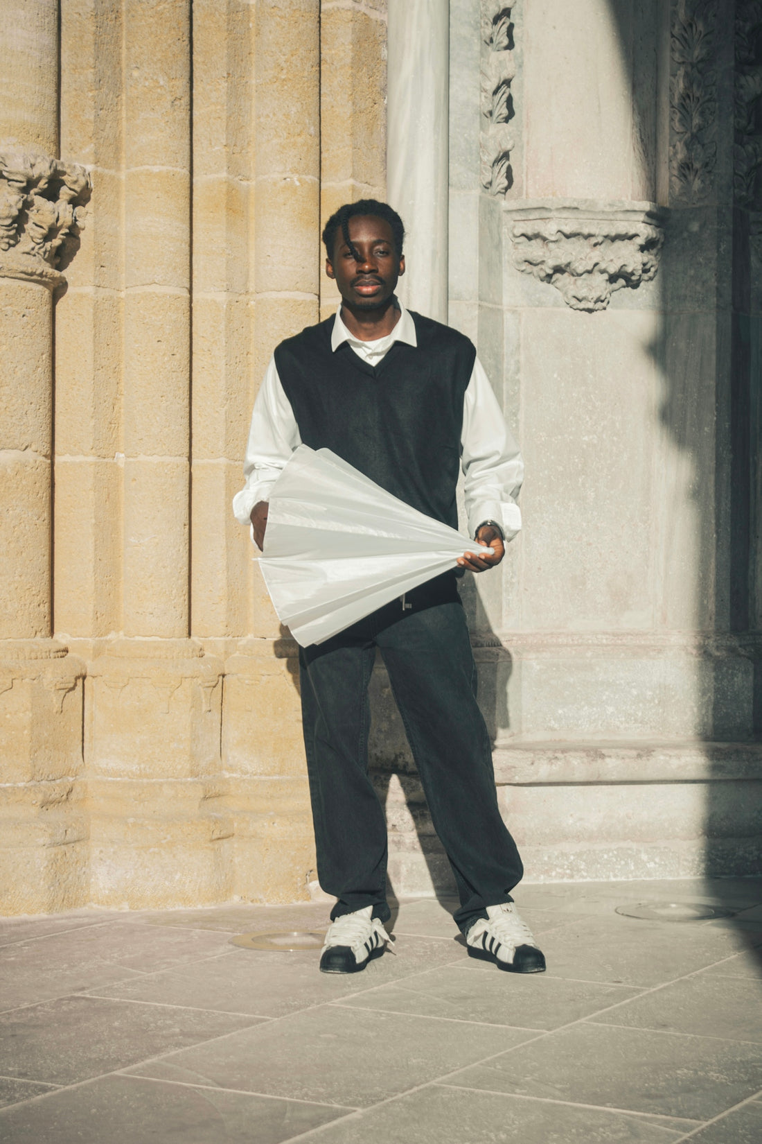 Young black man holding a white umbrella outdoors