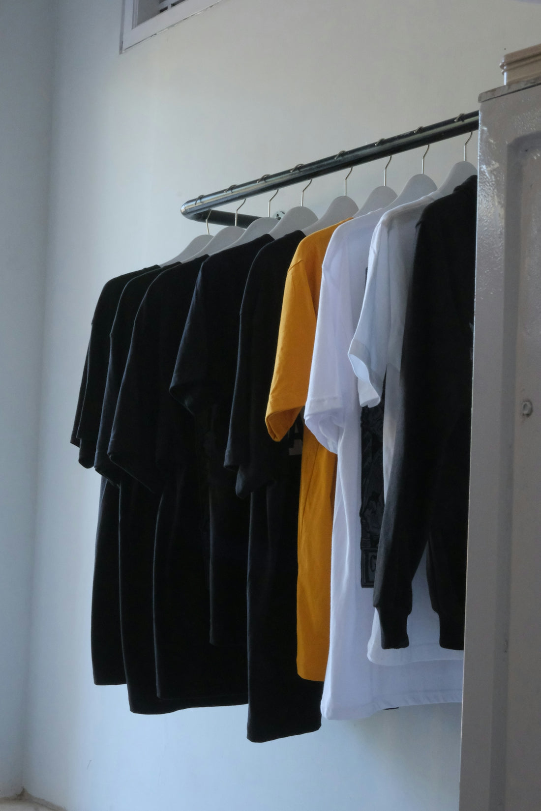 Assorted t-shirts hanging on a rack.